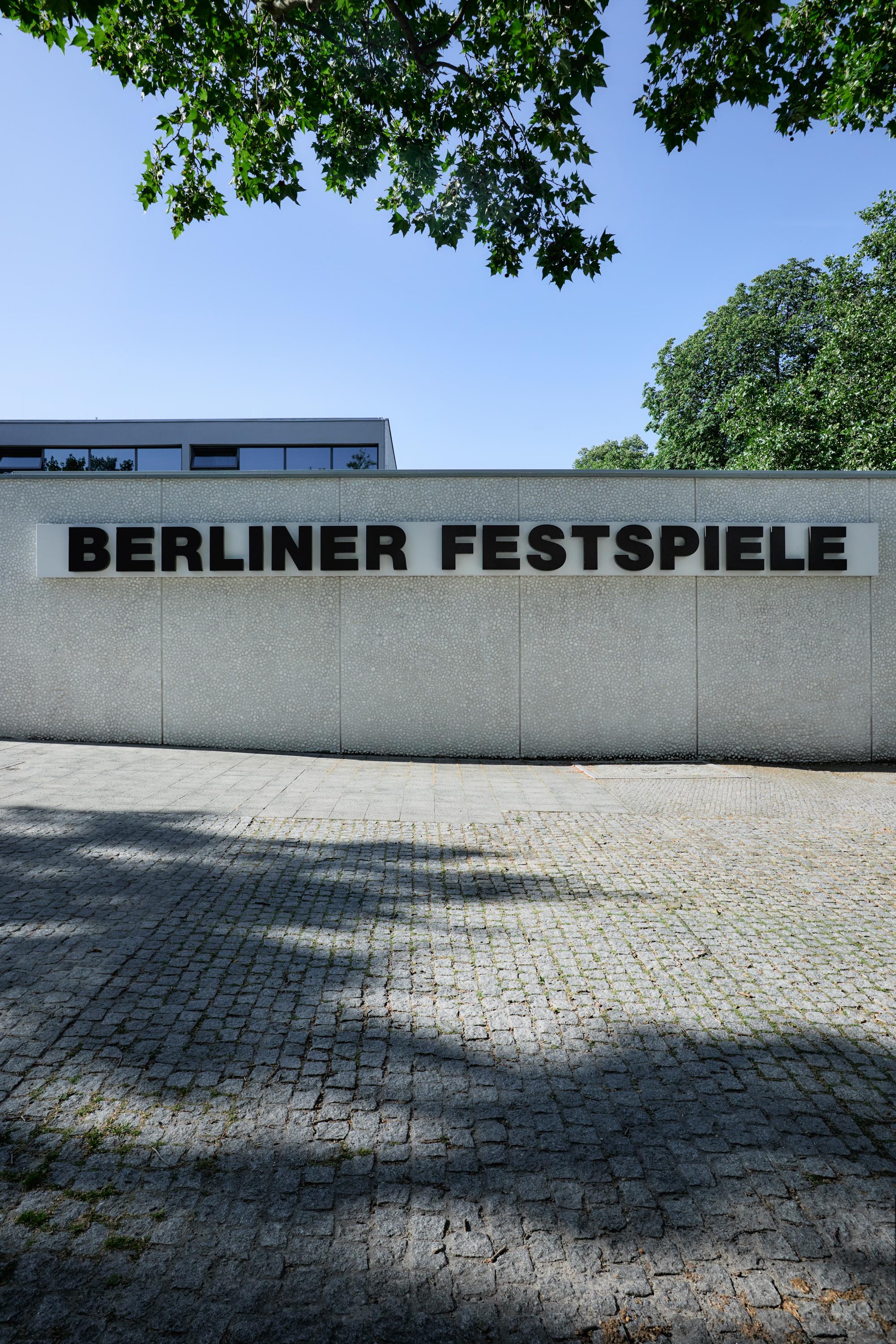 Frontal view of the Haus der Berliner Festspiele. You can see the Kassenhalle. "Berliner Festspiele" is written in black letters on the facade.