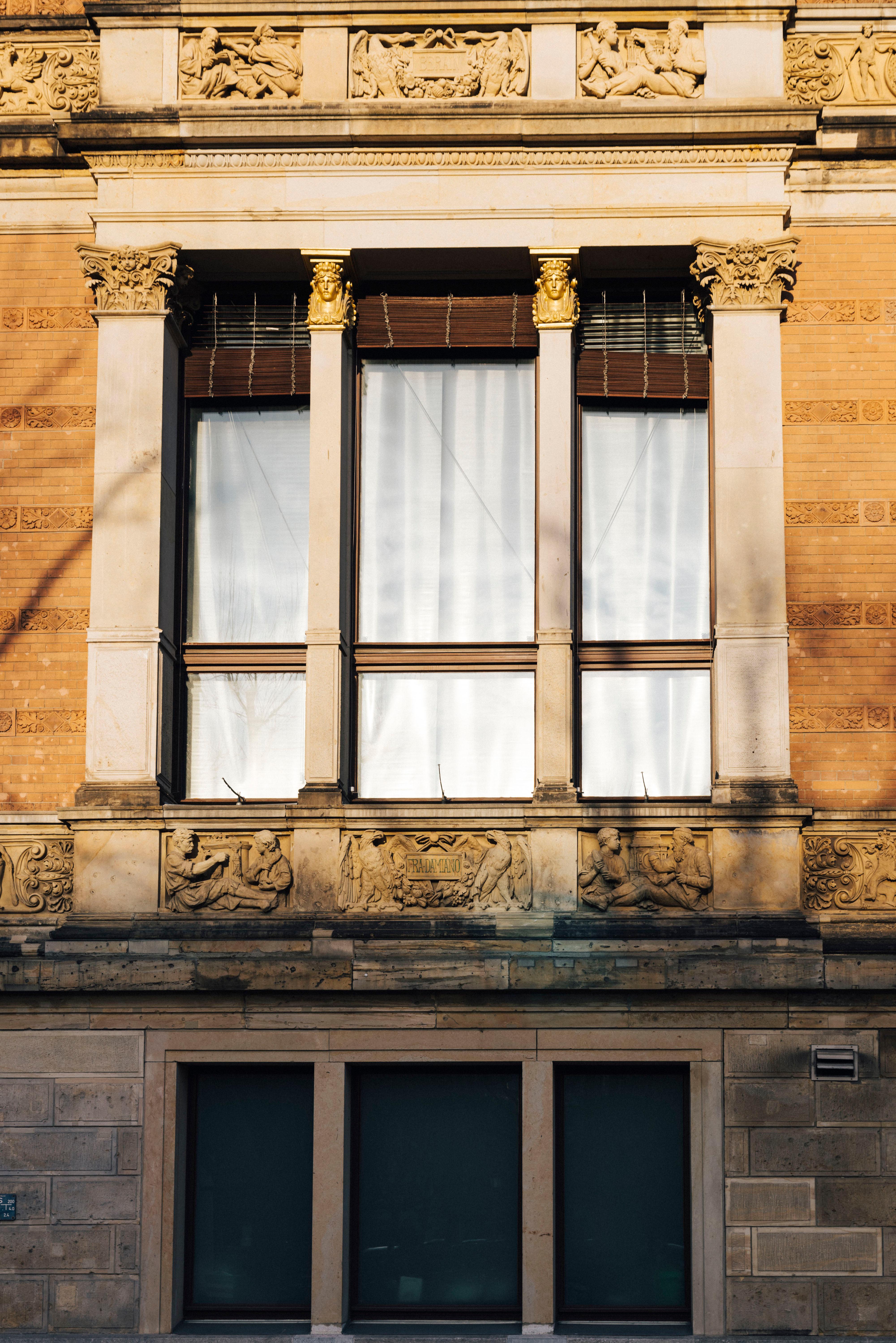 Frontal view of a window of the Gropius Bau building. Drawn white curtains can be seen.
